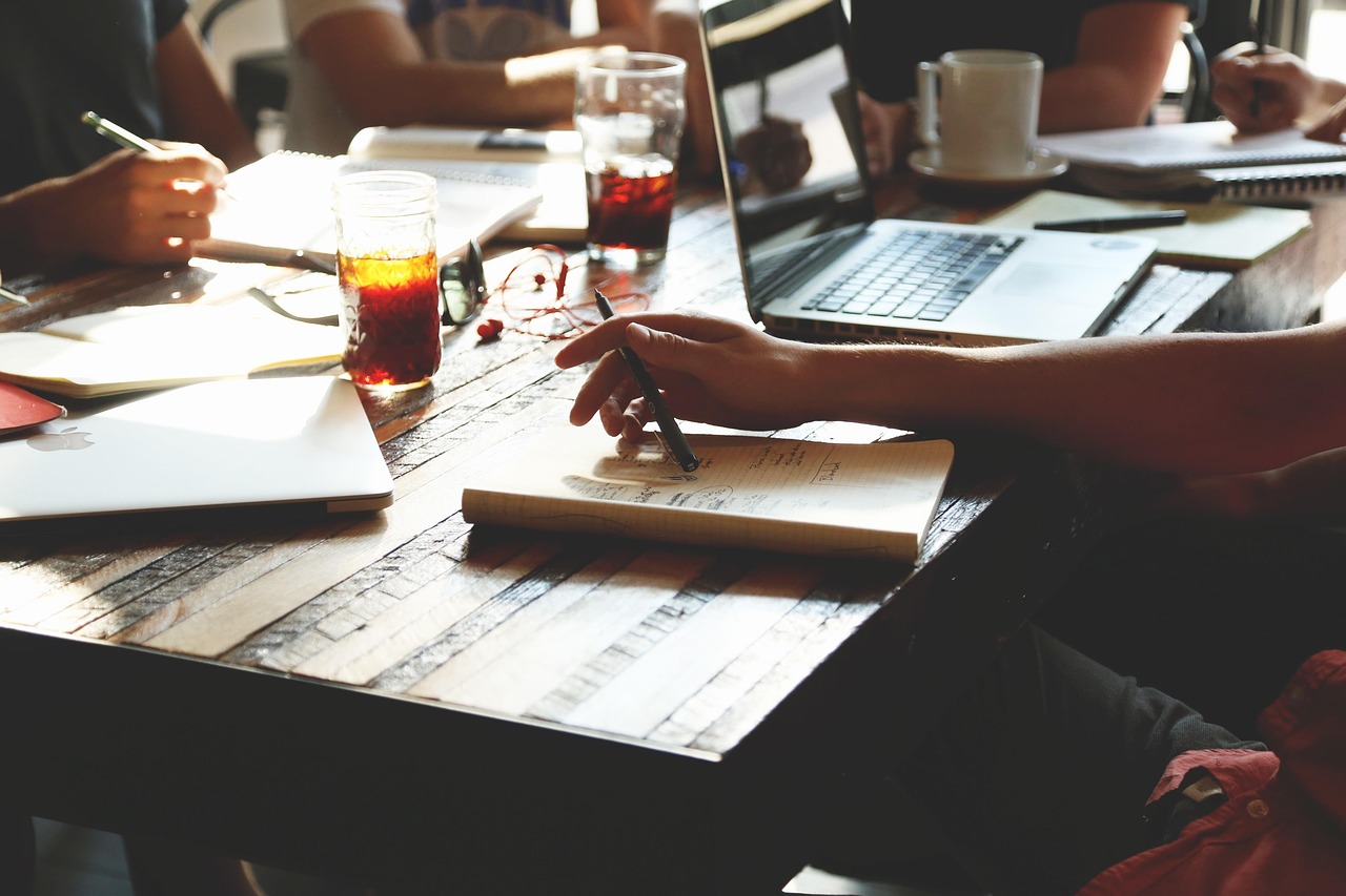 Team collaborating at a table with devices (stock photo).